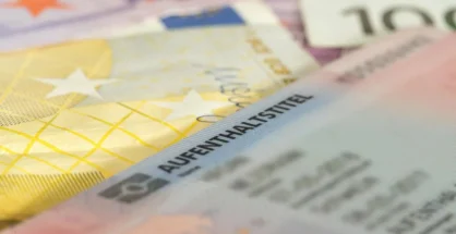 Austrian Residence Permit card with calculator showing new 2026 financial requirements.
