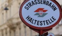 Public street sign and transit signage displaying German text in Vienna, Austria.