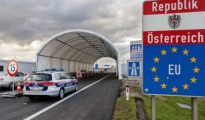 Austrian police car stationed at a land border control checkpoint with Republik Österreich and EU signage.