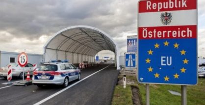 Austrian police car stationed at a land border control checkpoint with Republik Österreich and EU signage.