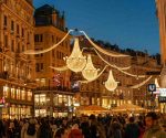 A vibrant evening shot of a decorated street in Vienna with people celebrating