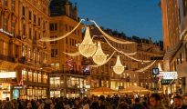 A vibrant evening shot of a decorated street in Vienna with people celebrating