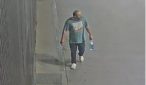 Surveillance camera footage showing the suspect walking along a sidewalk wearing a t-shirt, dark trousers, and white shoes
