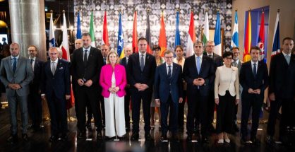 Foreign ministers and delegates from Western Balkan states and European Union members posing for a group photo in front of national flags at the Berlin Process summit in Montenegro
